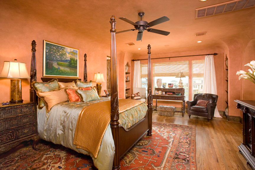 Diseño de dormitorio principal mediterráneo extra grande con parades naranjas y suelo de madera en tonos medios
