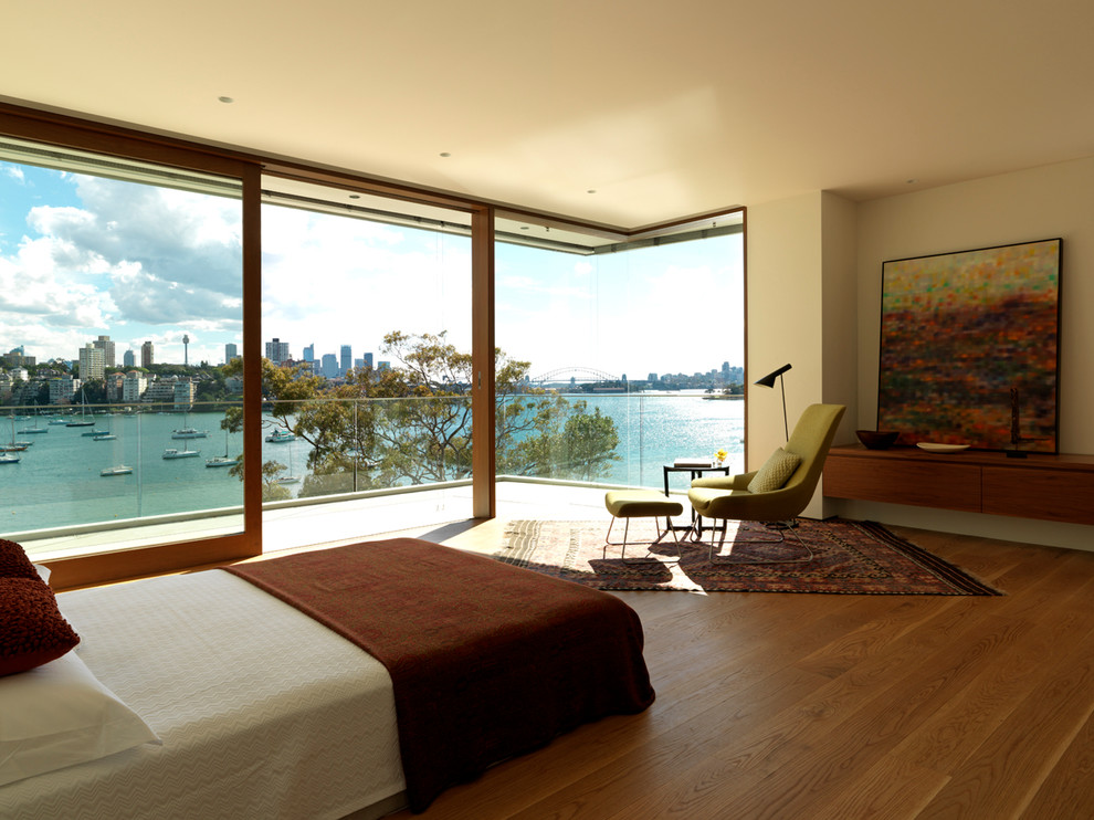 Bedroom - large contemporary master medium tone wood floor bedroom idea in Sydney with white walls