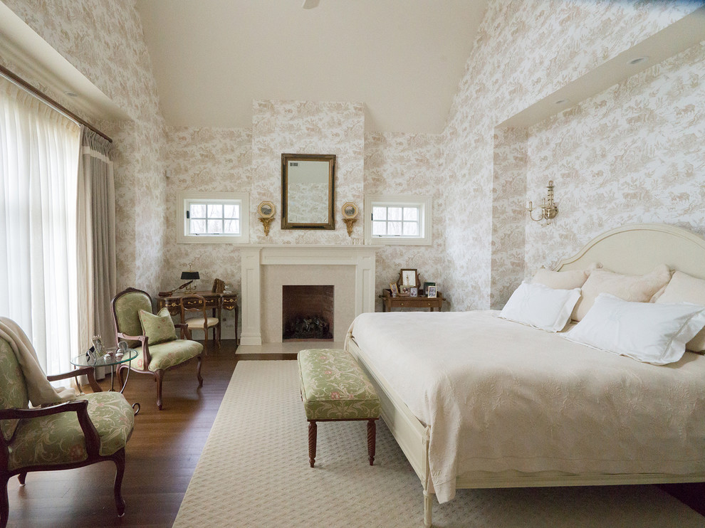 На фото: большая хозяйская спальня в классическом стиле с разноцветными стенами, стандартным камином, фасадом камина из дерева и паркетным полом среднего тона