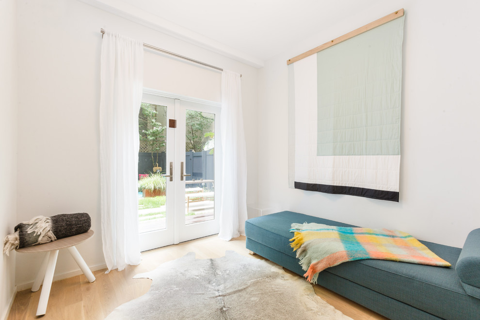 Idée de décoration pour une petite chambre d'amis nordique avec un mur blanc et parquet clair.