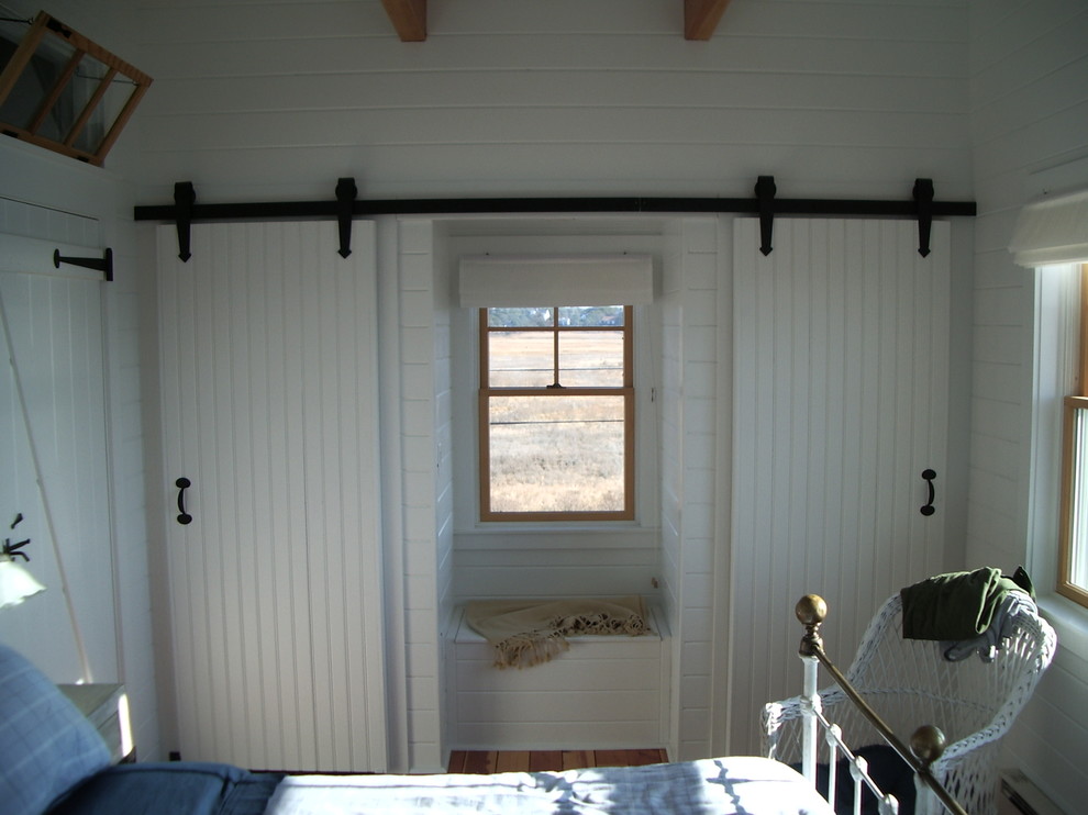Inspiration pour une chambre traditionnelle avec un mur blanc, un sol en bois brun et aucune cheminée.
