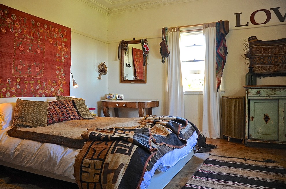 Diseño de dormitorio rústico sin chimenea con paredes beige y suelo de madera en tonos medios