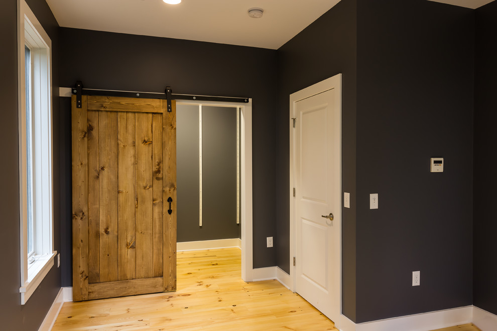 Kleines Modernes Hauptschlafzimmer mit schwarzer Wandfarbe und hellem Holzboden in Richmond