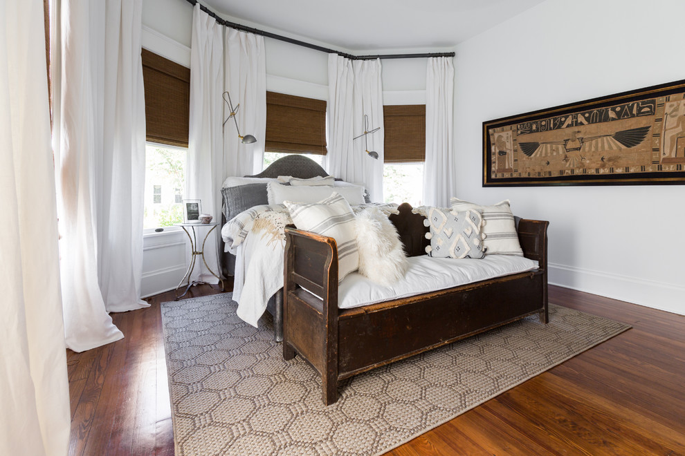 Ejemplo de dormitorio principal de estilo americano de tamaño medio con paredes blancas, suelo de madera oscura y suelo marrón