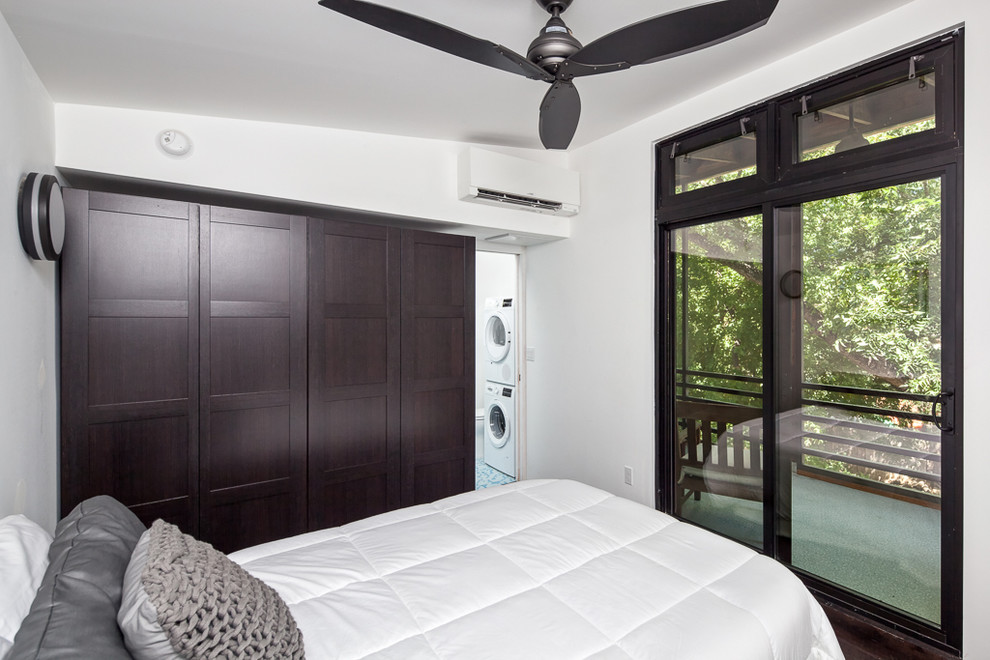 Kleines Modernes Gästezimmer ohne Kamin mit weißer Wandfarbe und braunem Holzboden in Austin