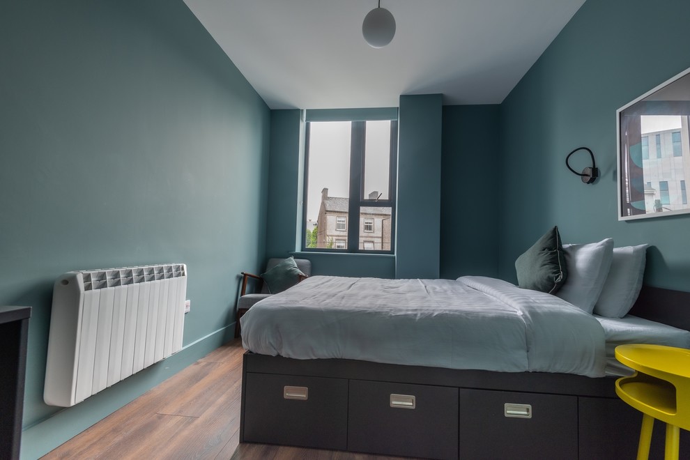 Foto de dormitorio principal, contemporáneo, pequeño, con paredes grises, suelo laminado y suelo marrón