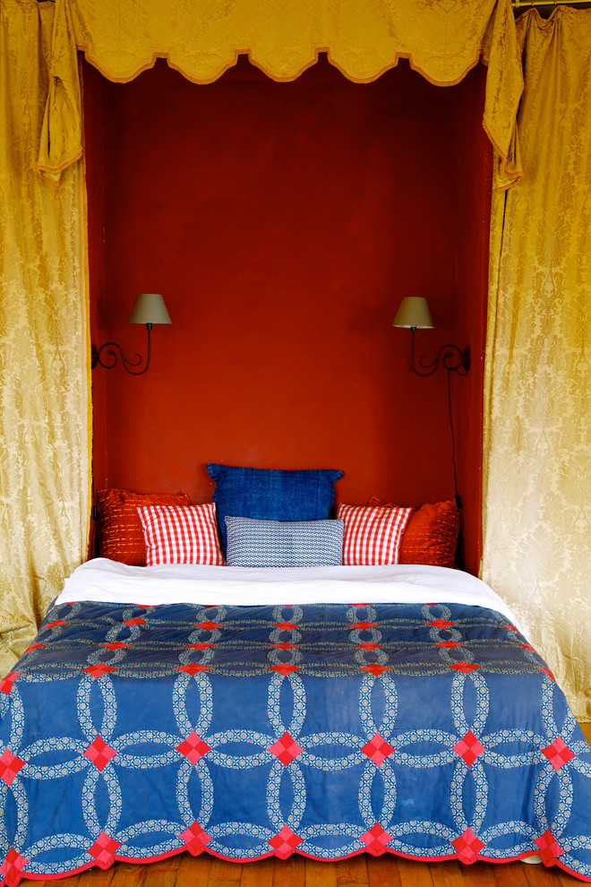 Aménagement d'une chambre d'amis méditerranéenne de taille moyenne avec un mur rouge et un sol en bois brun.