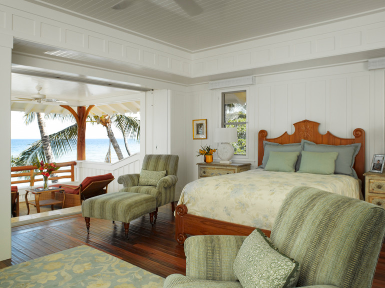 Foto di una piccola camera matrimoniale tropicale con pareti bianche e pavimento in legno massello medio