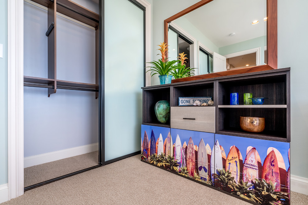 ハワイにある小さなトロピカルスタイルのおしゃれな客用寝室 (青い壁、カーペット敷き)
