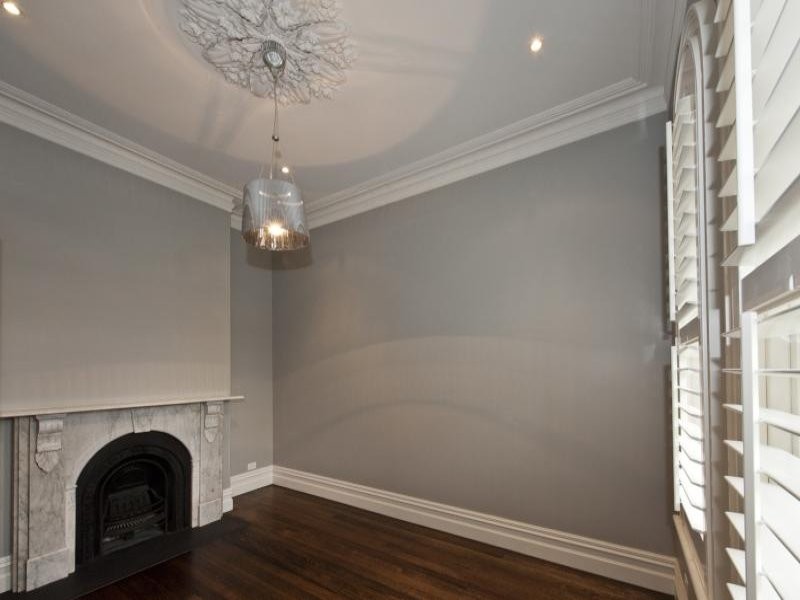 メルボルンにあるトランジショナルスタイルのおしゃれな寝室 (濃色無垢フローリング、標準型暖炉、茶色い床) のレイアウト