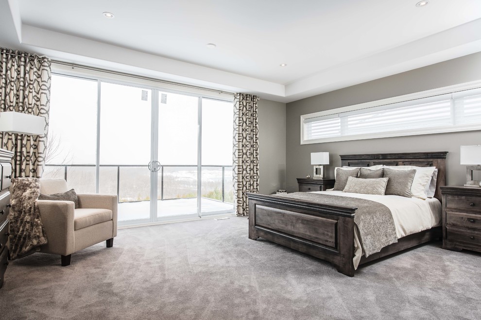 Large contemporary master bedroom in Toronto with grey walls, carpet and no fireplace.