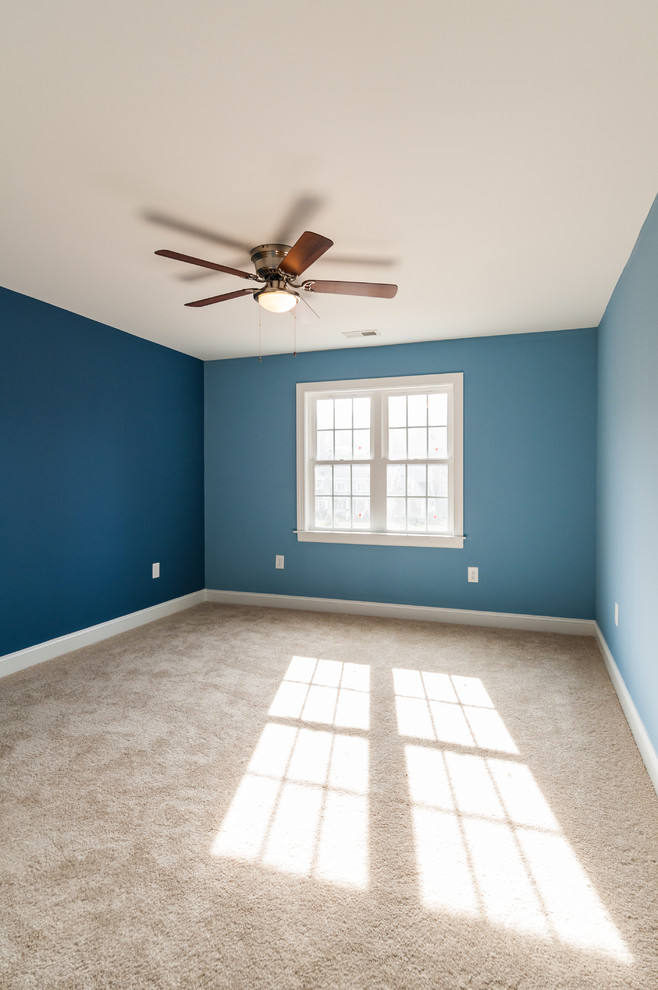 Inredning av ett amerikanskt mellanstort gästrum, med blå väggar, heltäckningsmatta och beiget golv
