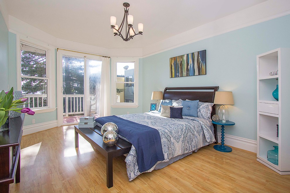 Diseño de habitación de invitados clásica renovada grande sin chimenea con paredes azules y suelo de madera clara