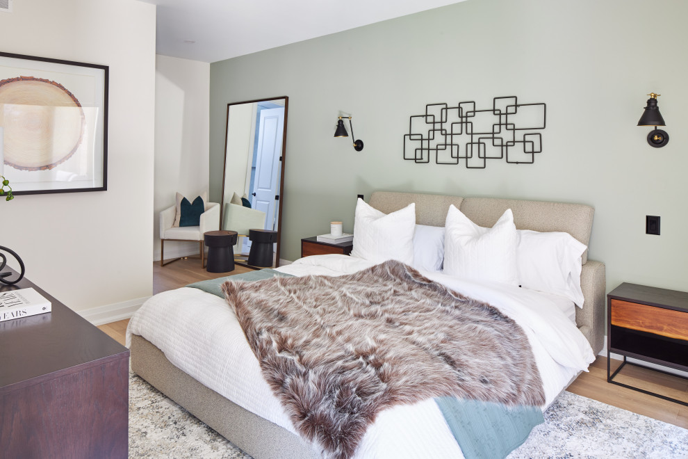 Immagine di una camera da letto minimal con pareti verdi, pavimento in legno massello medio e pavimento marrone