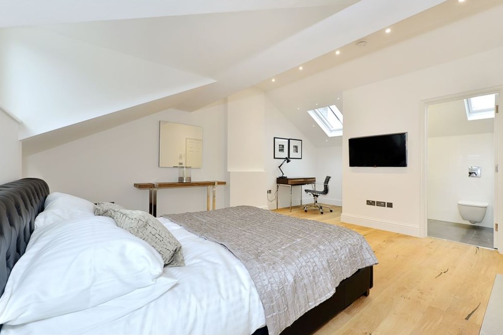This is an example of a medium sized contemporary master bedroom in London with white walls, light hardwood flooring and beige floors.