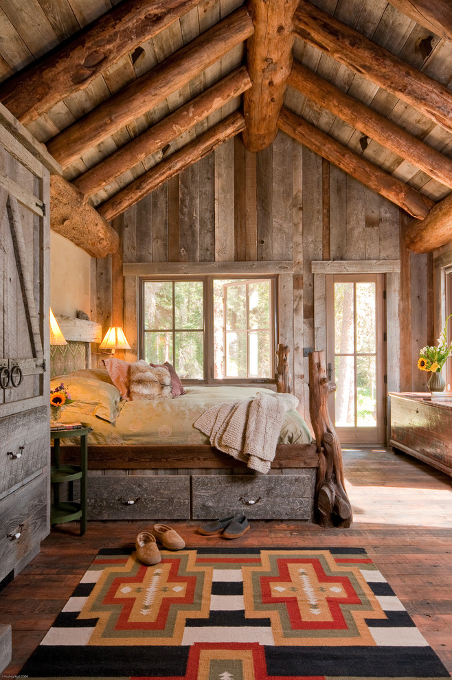 Bedroom - rustic medium tone wood floor bedroom idea in Other with beige walls