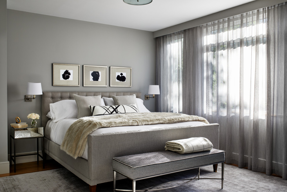 Ejemplo de dormitorio principal clásico renovado de tamaño medio sin chimenea con paredes grises, suelo de madera en tonos medios y suelo marrón