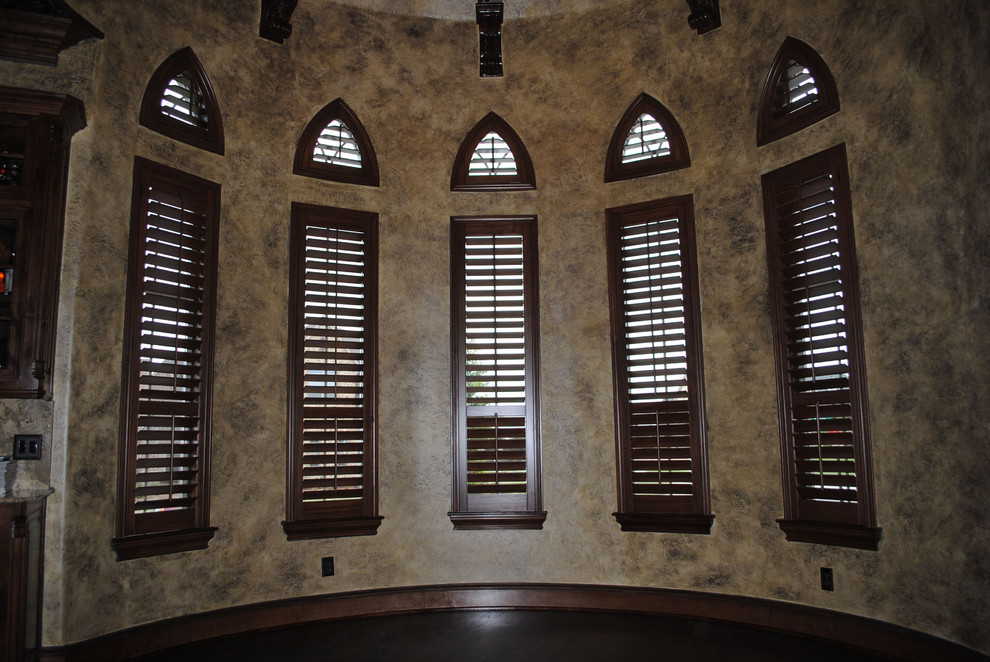 Inspiration for a large mediterranean bedroom in Dallas with brown walls, dark hardwood flooring and brown floors.