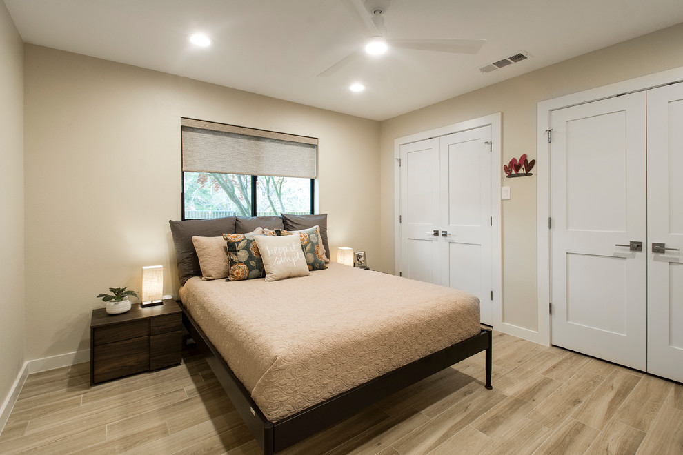 Foto di una camera degli ospiti stile americano di medie dimensioni con pareti beige, parquet chiaro, nessun camino e pavimento beige