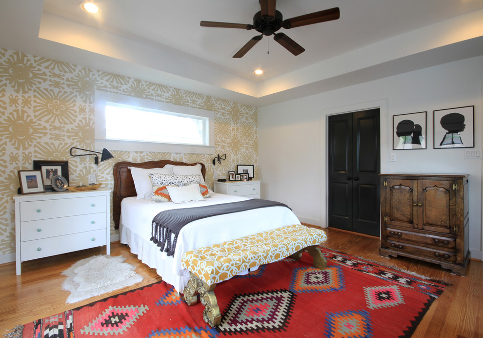 Eclectic master bedroom in Houston with white walls and medium hardwood flooring.