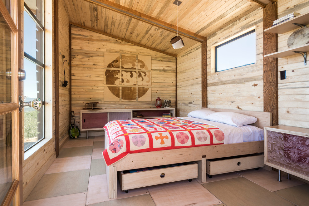 Example of a small mountain style light wood floor and multicolored floor bedroom design in Denver with brown walls