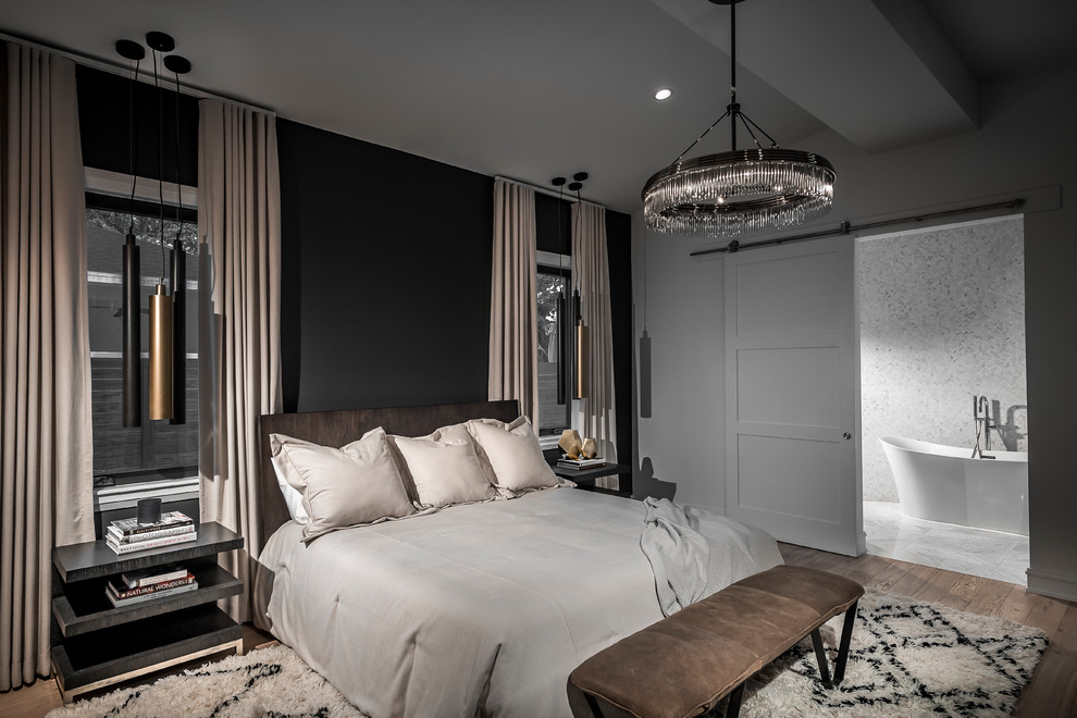 Immagine di una camera matrimoniale minimal con pareti nere, pavimento in legno massello medio e pavimento marrone