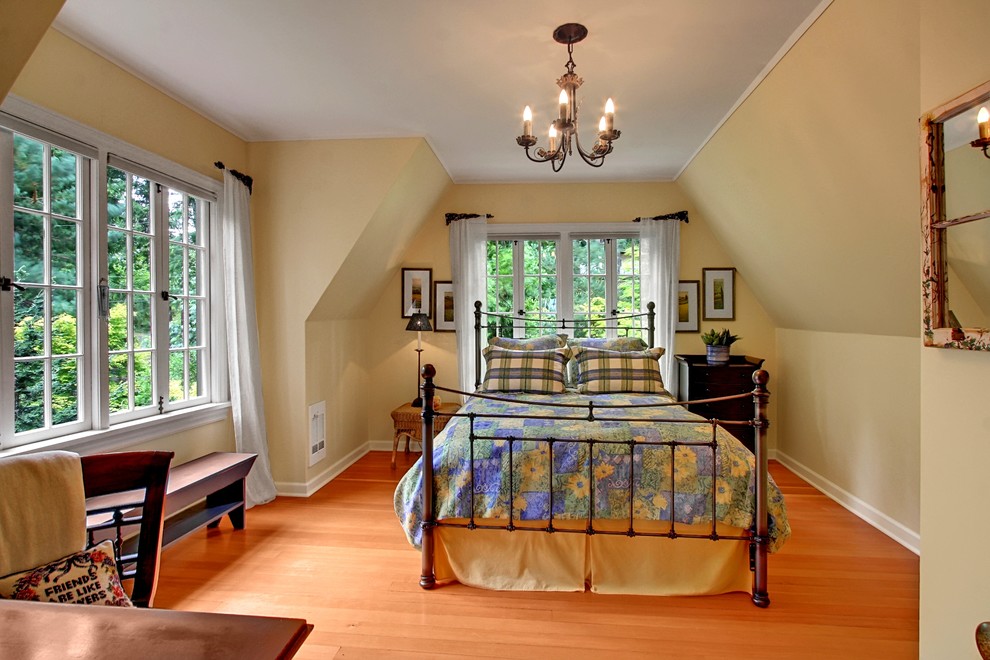 Exemple d'une chambre nature de taille moyenne avec un sol en bois brun, un mur jaune et un sol orange.