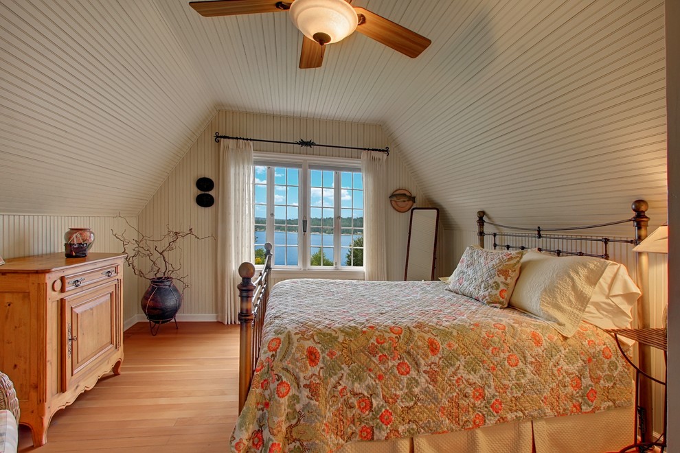 Modelo de dormitorio campestre de tamaño medio con suelo de madera en tonos medios