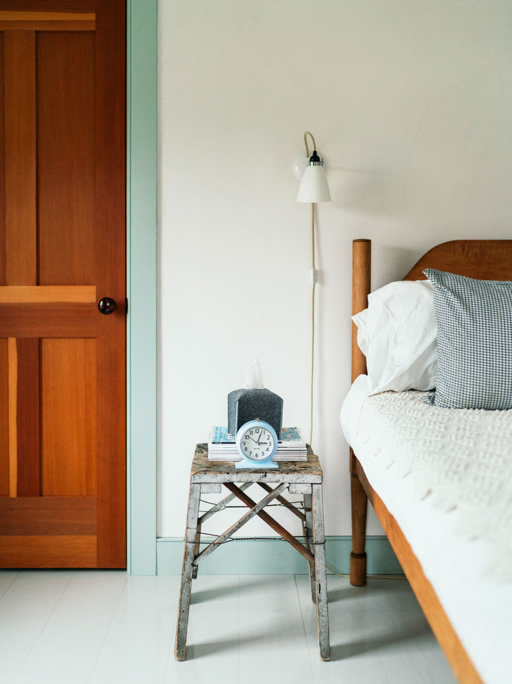 Country Schlafzimmer mit grüner Wandfarbe, hellem Holzboden, Kaminumrandung aus Backstein und grauem Boden in New York
