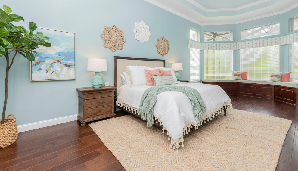 Foto di una camera da letto costiera con pareti blu, parquet scuro e pavimento marrone
