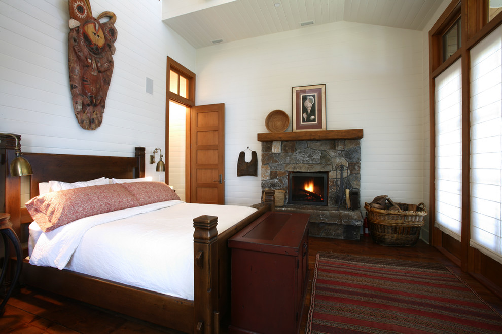 Imagen de dormitorio rústico con marco de chimenea de piedra y todas las chimeneas