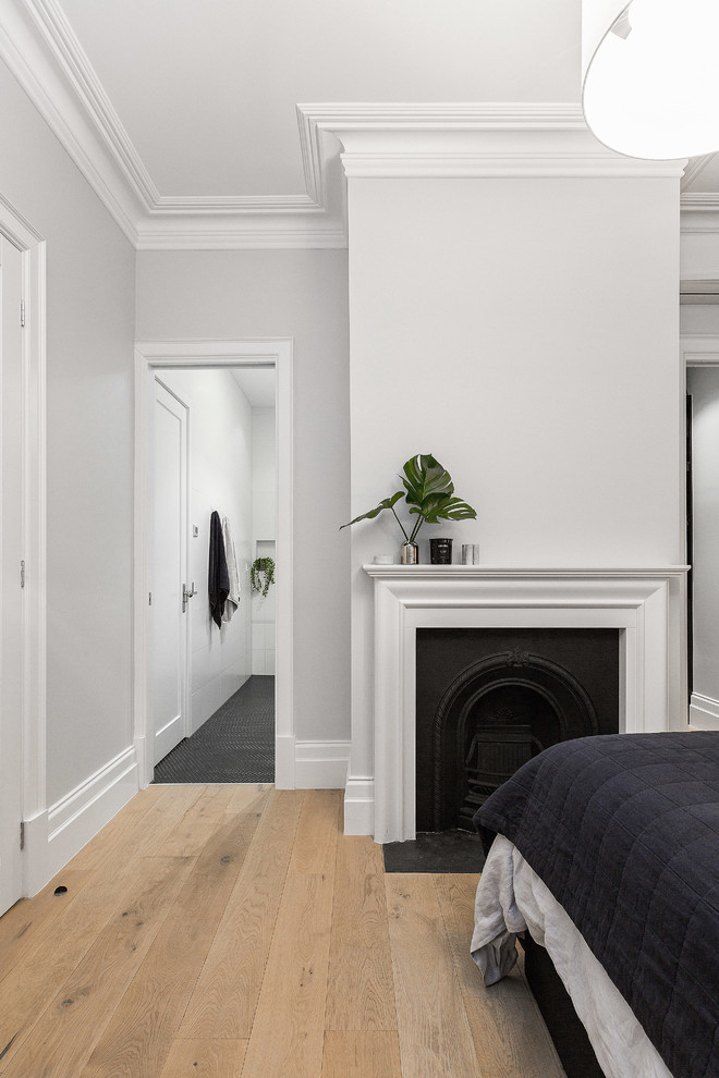 Идея дизайна: хозяйская спальня среднего размера в современном стиле с серыми стенами, светлым паркетным полом, стандартным камином и фасадом камина из металла