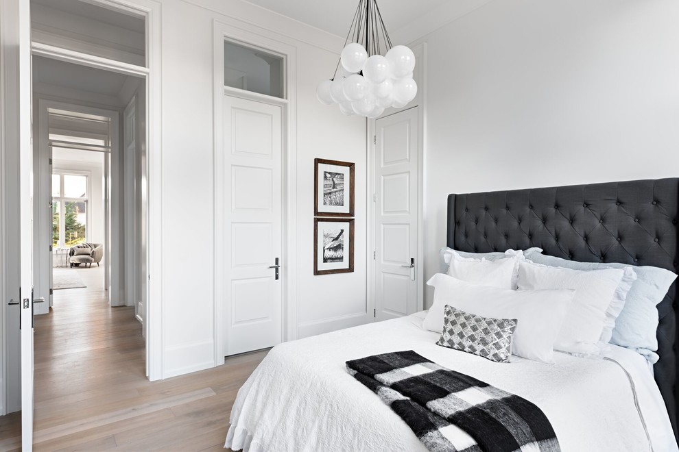 Photo of a contemporary master bedroom in Toronto with white walls, light hardwood flooring, no fireplace and beige floors.