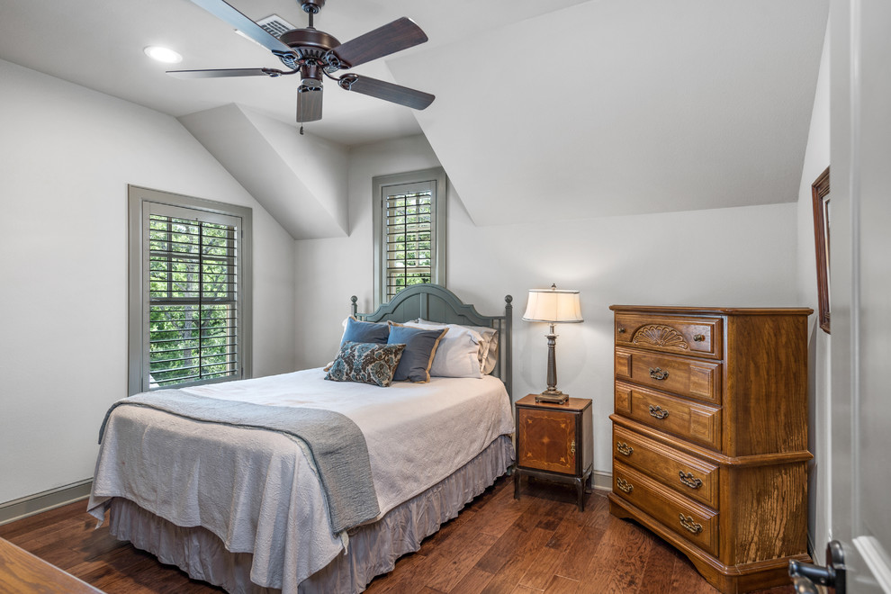 Design ideas for a classic guest bedroom in Austin with white walls, dark hardwood flooring and brown floors.