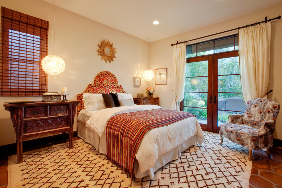 Mediterranes Schlafzimmer mit beiger Wandfarbe und Terrakottaboden in Los Angeles