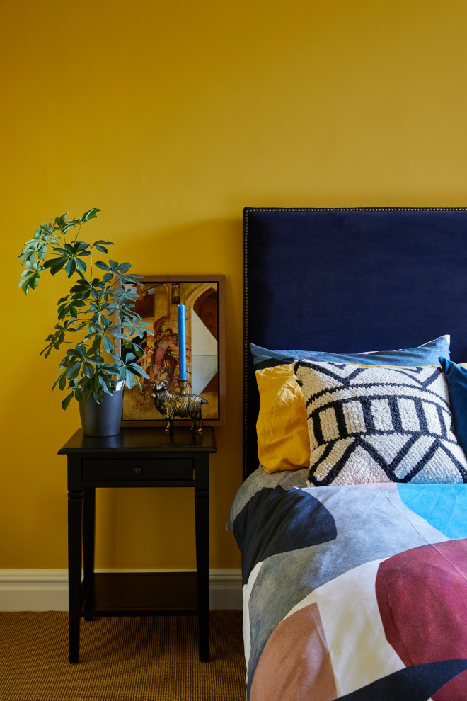 This is an example of a contemporary guest bedroom in London with yellow walls.