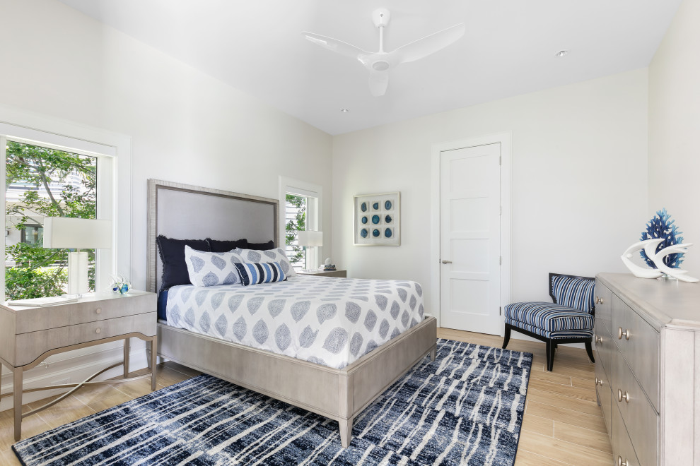 Bedroom - coastal guest medium tone wood floor and brown floor bedroom idea in Tampa with white walls and no fireplace