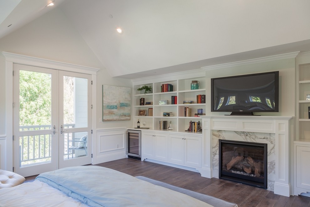 Large nautical master bedroom in Los Angeles with white walls, medium hardwood flooring, a standard fireplace and a stone fireplace surround.