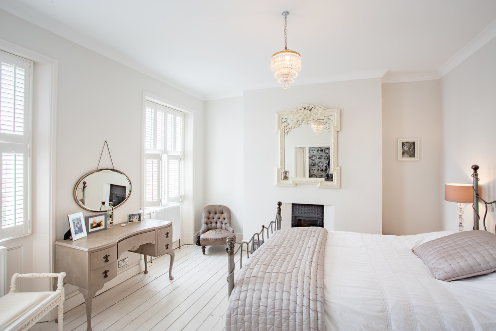 ロンドンにある中くらいなトランジショナルスタイルのおしゃれな寝室 (グレーの壁、塗装フローリング、標準型暖炉、漆喰の暖炉まわり、白い床) のレイアウト