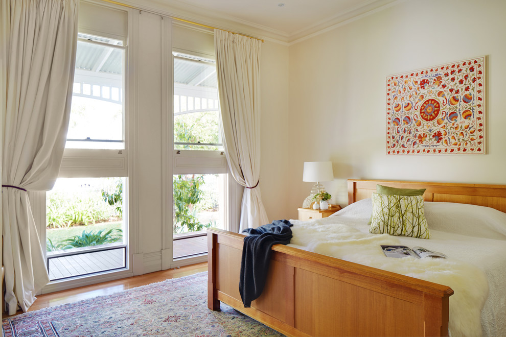 Diseño de dormitorio tradicional renovado sin chimenea con paredes beige y suelo de madera en tonos medios