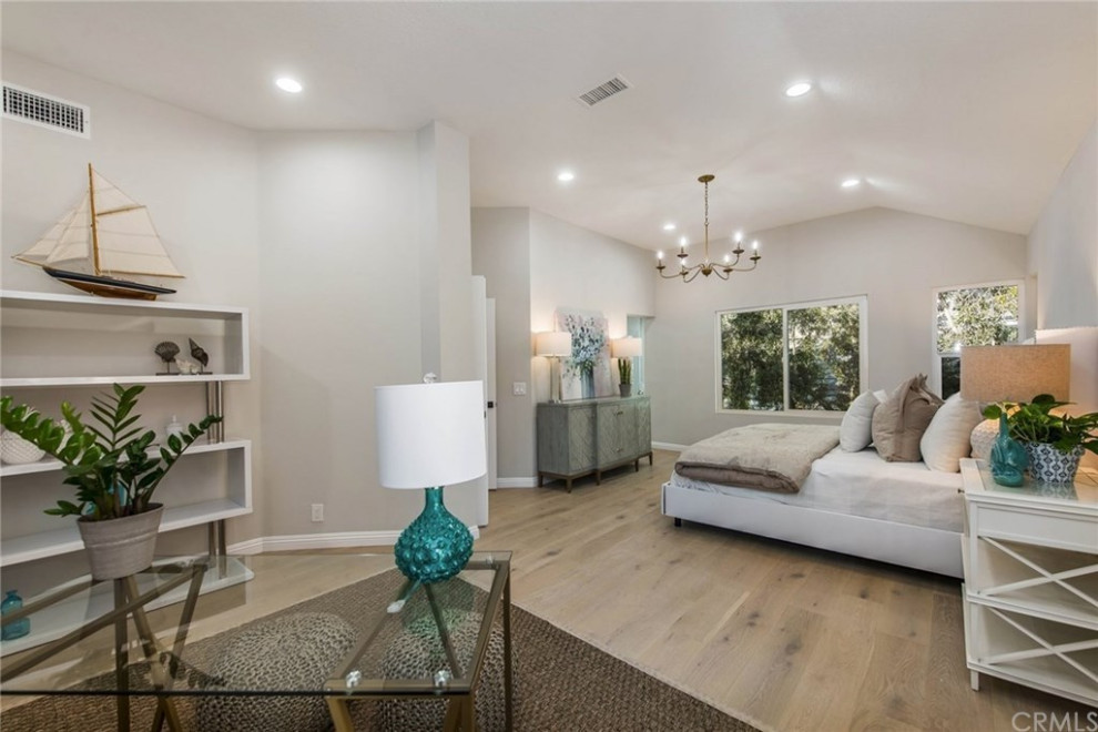 Maritimes Schlafzimmer mit weißer Wandfarbe und hellem Holzboden in Orange County