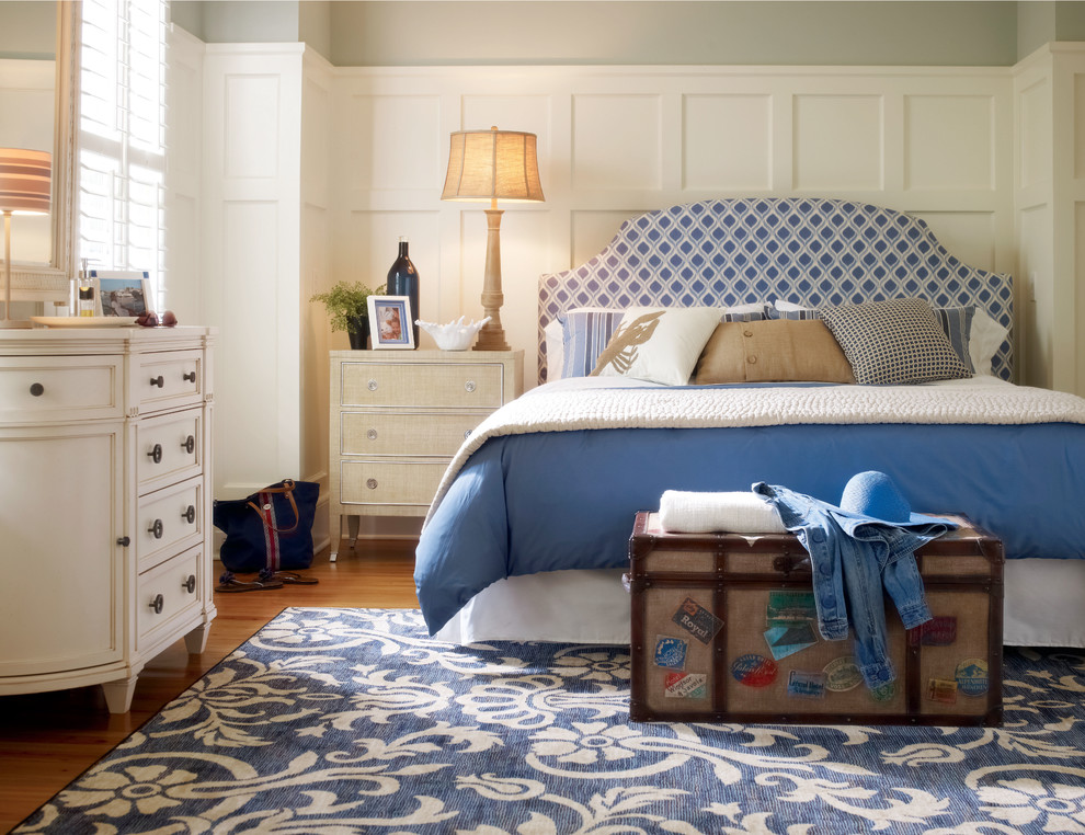Ejemplo de habitación de invitados costera de tamaño medio con paredes grises y suelo de madera en tonos medios