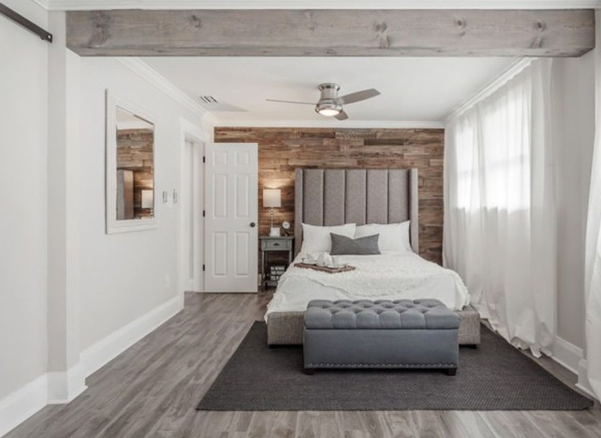 タンパにある広いトランジショナルスタイルのおしゃれな主寝室 (白い壁、ラミネートの床)