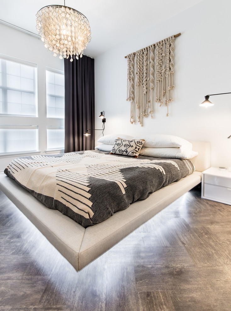 Immagine di una camera matrimoniale moderna di medie dimensioni con pareti bianche, pavimento in vinile e pavimento marrone
