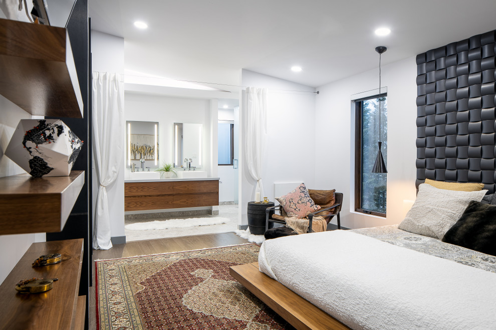 Modernes Hauptschlafzimmer mit weißer Wandfarbe, dunklem Holzboden, braunem Boden und gewölbter Decke in Edmonton