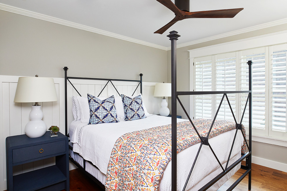 Idées déco pour une chambre d'amis bord de mer de taille moyenne avec un mur gris, un sol en bois brun et aucune cheminée.