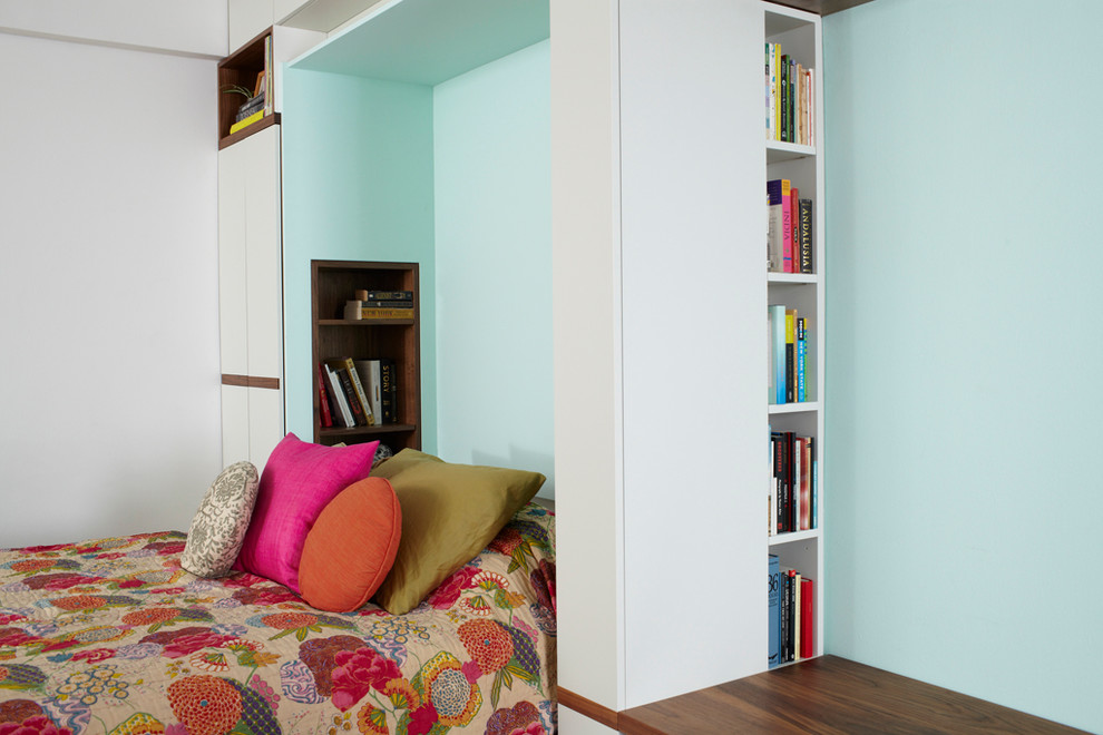 Ispirazione per una camera degli ospiti minimalista di medie dimensioni con pareti blu e pavimento in legno massello medio