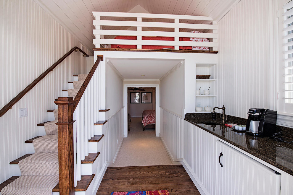 Foto de dormitorio tipo loft exótico grande sin chimenea con paredes blancas y suelo de madera oscura