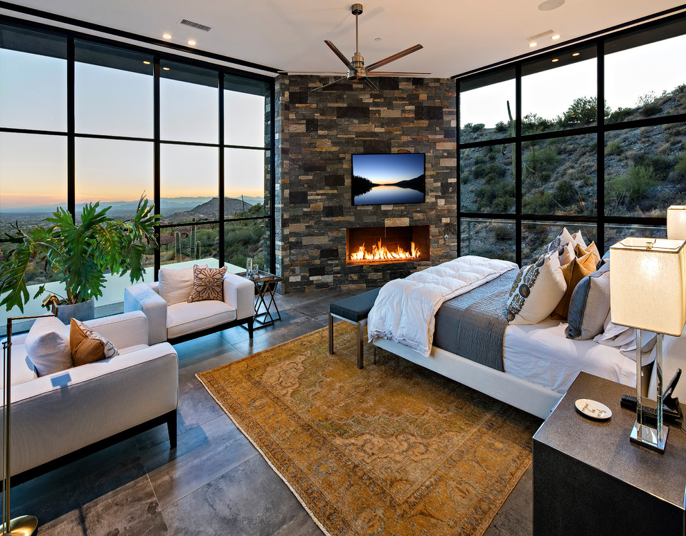 フェニックスにある広いコンテンポラリースタイルのおしゃれな主寝室 (磁器タイルの床、横長型暖炉、石材の暖炉まわり)