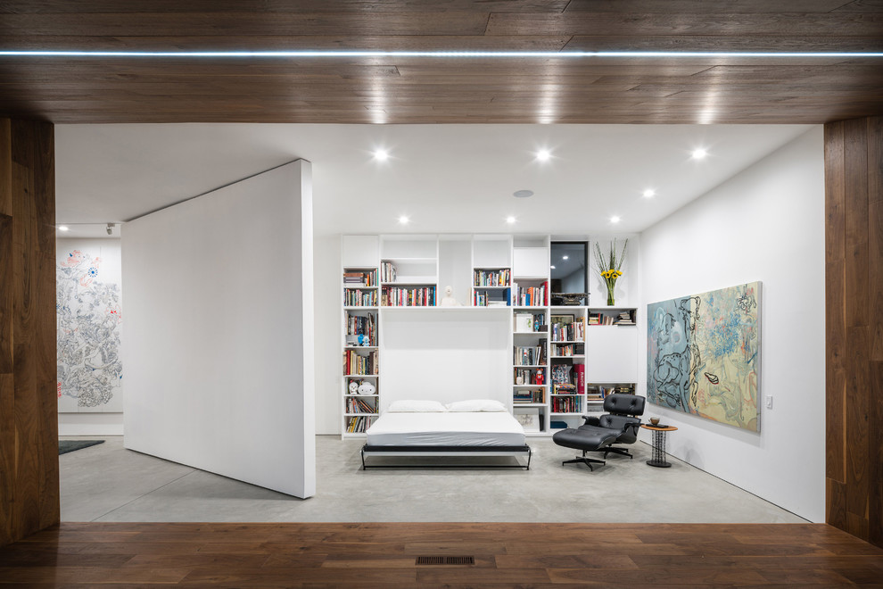 Foto di una camera da letto moderna con pareti bianche, pavimento in cemento e pavimento grigio